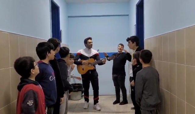 Yatılı okulda müzik öğretmeni öğrencileri gitar çalıp şarkı söyleyerek uyandırıyor