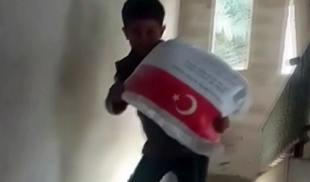 Kendi ağırlığı kadar un çuvalını taşıyan Filistinli çocuğun sevinci